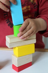 enfant empilant des formes en bois