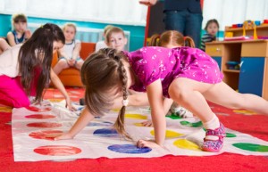 Cute toddlers playing in twister game
